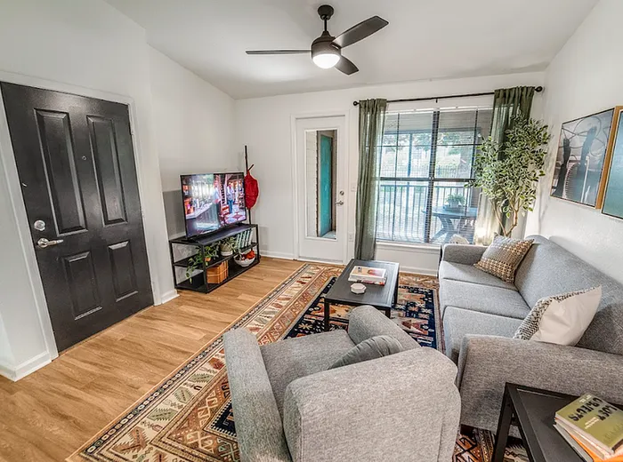 Furnished living room with balcony in a deluxe apartment at The Lodge of Athens student housing