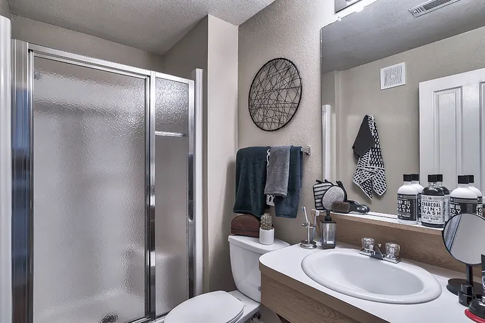 Apartment bathroom with shower and vanity at The Lodge of Athens student apartments
