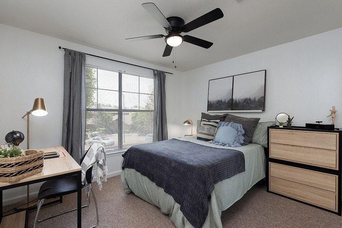 Furnished bedroom with desk and large window at The Lodge of Athens student apartments
