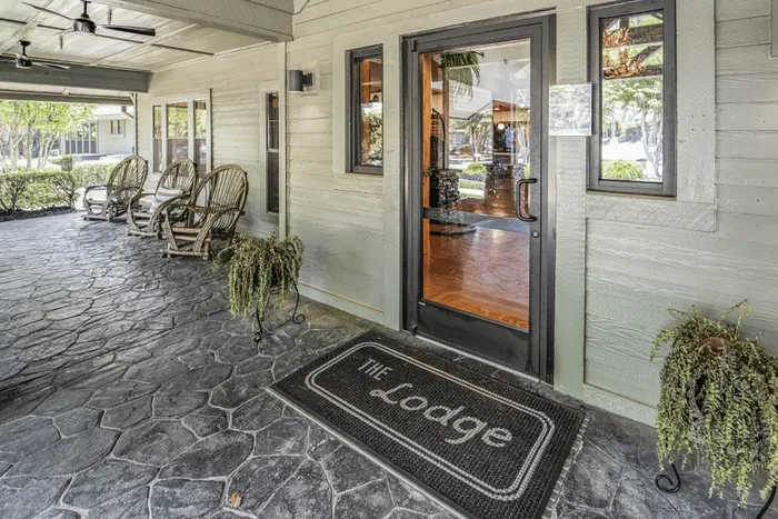 Entrance to The Lodge of Athens leasing office with porch seating