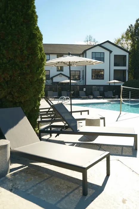 Poolside lounge chairs and umbrellas beside the resort-style pool at The Lodge of Athens