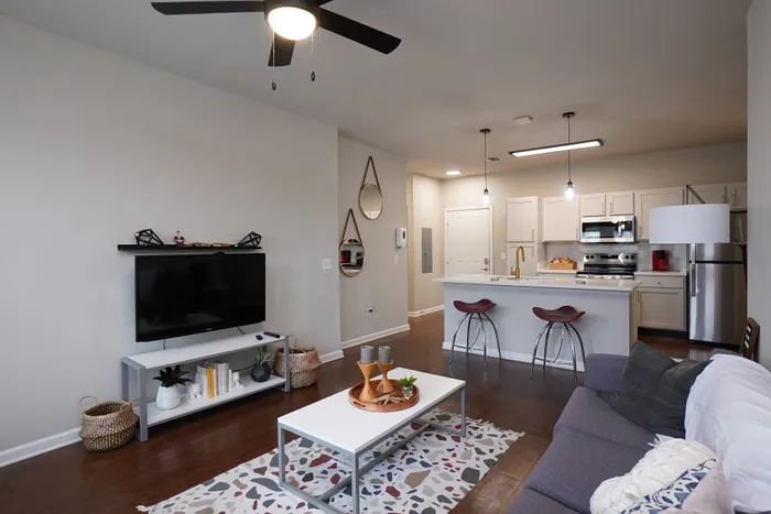 Chic apartment interior featuring a modern living room with stylish decor, an open-concept kitchen with a breakfast bar, and elegant lighting.