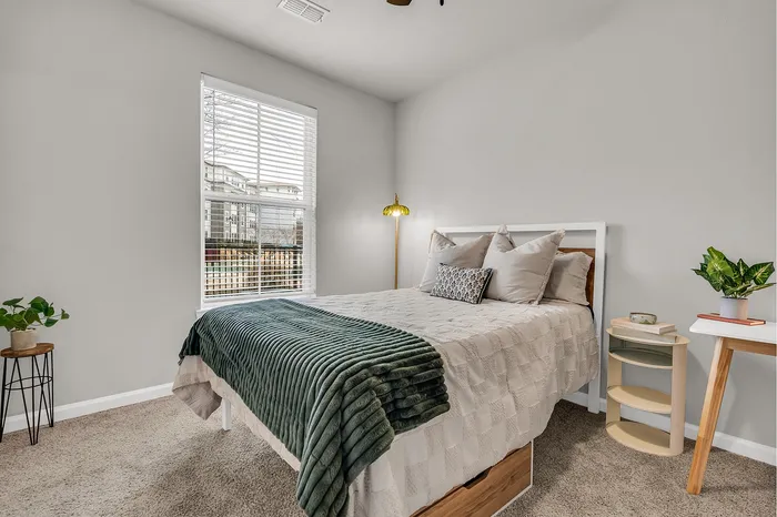 Inviting bedroom with a cozy bed, elegant decor, and abundant natural light, perfect for relaxation.