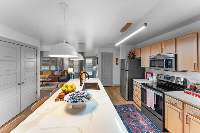 Modern apartment kitchen with large island and stainless appliances at Wildwood Baton Rouge student apartments near LSU