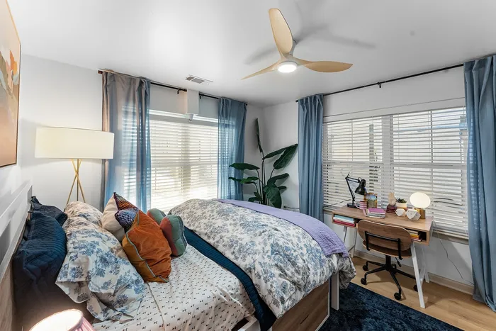 Furnished bedroom with study desk and natural light at Wildwood Baton Rouge student apartments near LSU