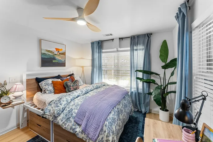 Bright furnished bedroom with large windows at Wildwood Baton Rouge student apartments near LSU