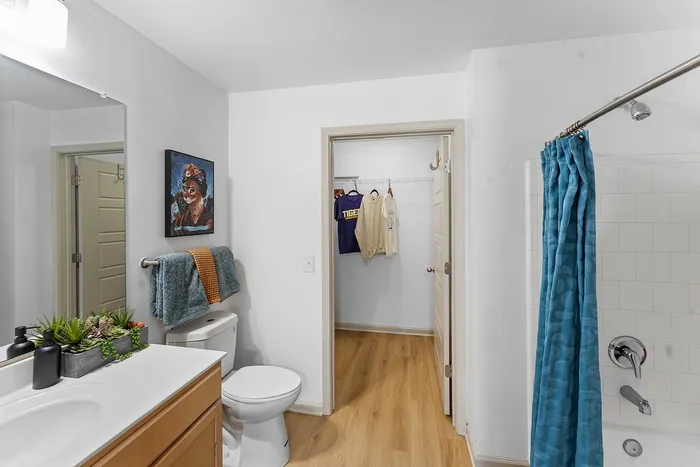 Private bathroom with tub shower and walk-in closet at Wildwood Baton Rouge student apartments near LSU