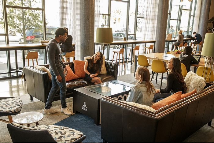 Chic communal lounge with stylish seating, modern decor, and large windows providing ample natural light, perfect for socializing or relaxation.