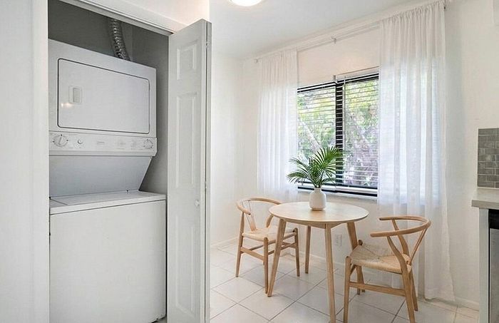 Bright and airy apartment with in-unit stacked washer and dryer, cozy dining area with natural light, and stylish decor.