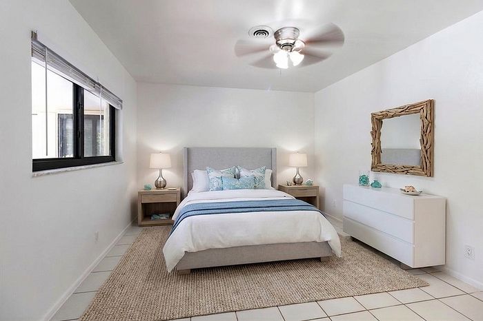 Inviting bedroom with modern decor, featuring a plush bed, stylish nightstands, and a chic mirror.