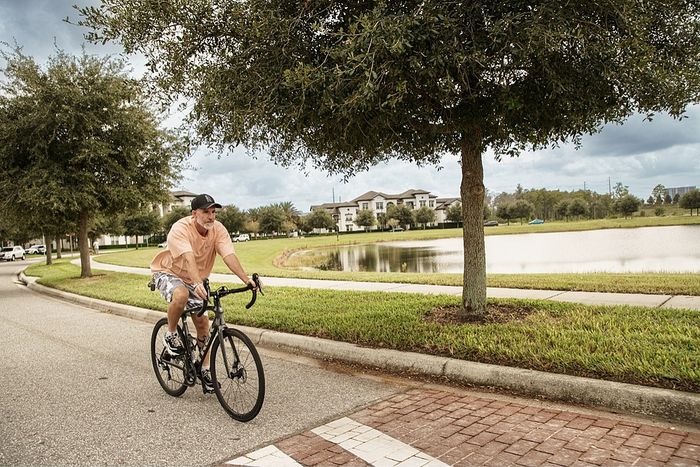Serene suburban neighborhood with scenic pond view and tree-lined pathways, ideal for cycling and leisurely strolls.