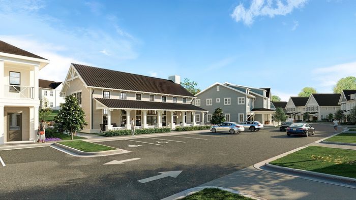 Charming residential complex featuring modern architecture, green surroundings, and spacious parking areas under a clear blue sky.
