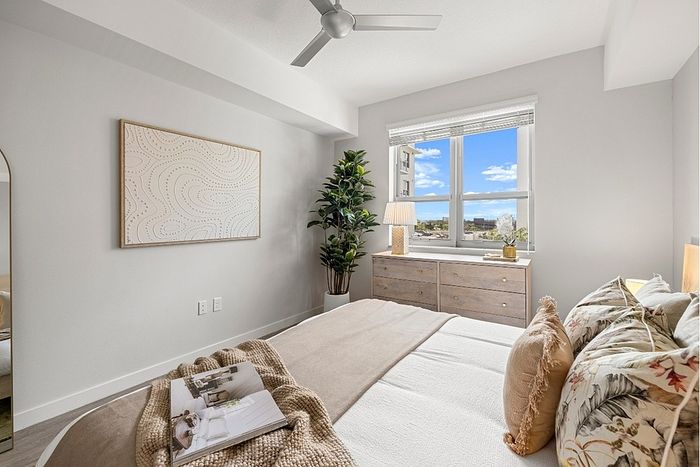 Bright and modern bedroom with stylish decor, large window view, and cozy bedding for a relaxing atmosphere.