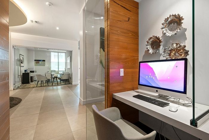 Modern workspace nook with iMac, sleek design, and vibrant decor in a stylish apartment.