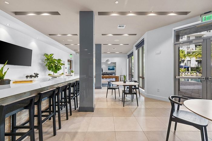 Modern communal space with elegant seating and abundant natural light, perfect for social gatherings.