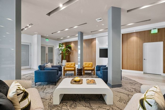Modern lounge area with sleek furniture featuring vibrant blue and yellow seating, contemporary decor, and a stylish coffee table, ideal for relaxation and social gatherings.