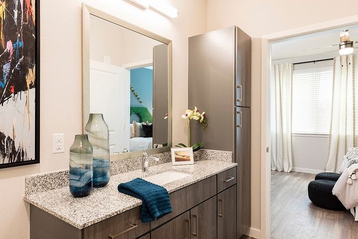 Elegant bathroom with stylish vanity, contemporary decor, and a glimpse of inviting bedrooms in a modern apartment.