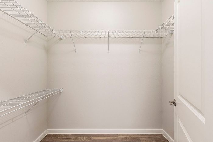 Spacious walk-in closet with sleek wire shelving, perfect for organized storage and optimizing space.