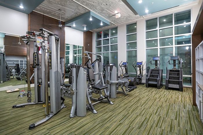 Modern fitness center with state-of-the-art exercise equipment, featuring large windows for natural light and a stylish design.