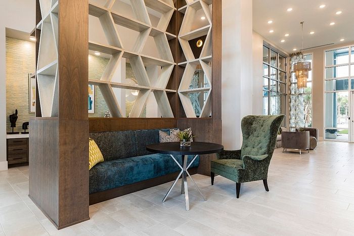 Elegant modern living space featuring chic geometric shelving, plush seating, and large windows offering abundant natural light.