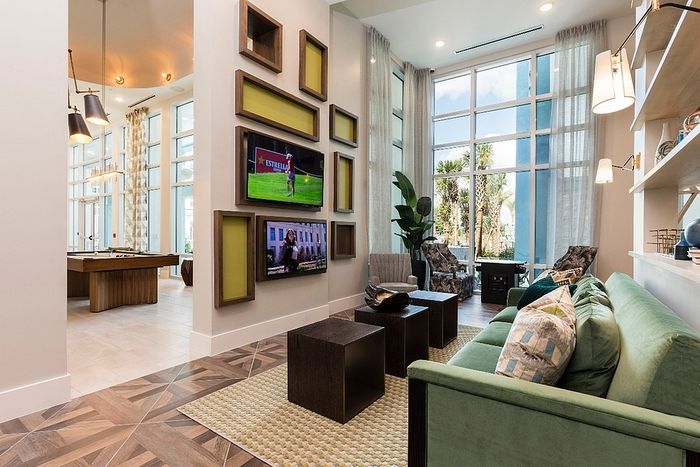 Chic and modern lounge area with large windows, stylish decor, and a cozy seating arrangement enhanced by natural light.