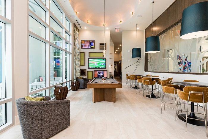 Luxurious communal space with modern seating, a sleek pool table, and vibrant decor, perfect for socializing and relaxation.