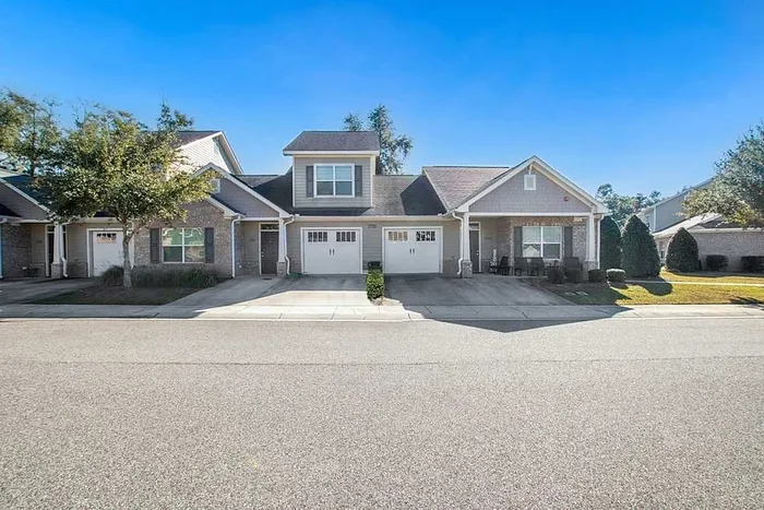 Charming townhouse with dual garages and a welcoming front porch set in a serene neighborhood.