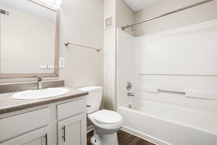 Modern bathroom featuring sleek fixtures, a spacious bathtub, and elegant cabinetry with ample storage.