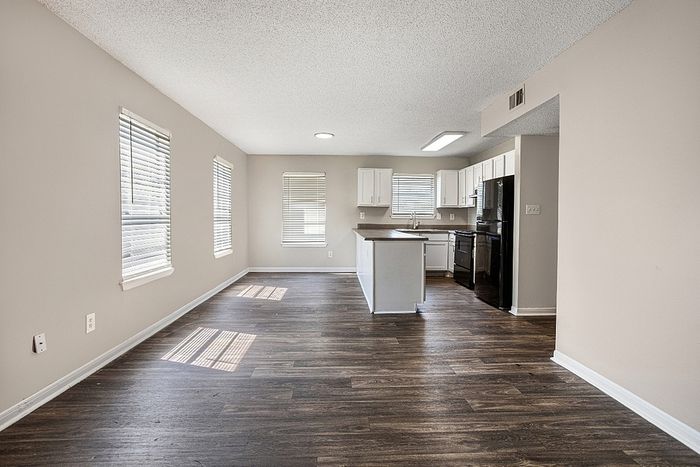 Bright open-concept kitchen and living area with stylish hardwood floors and ample natural light.