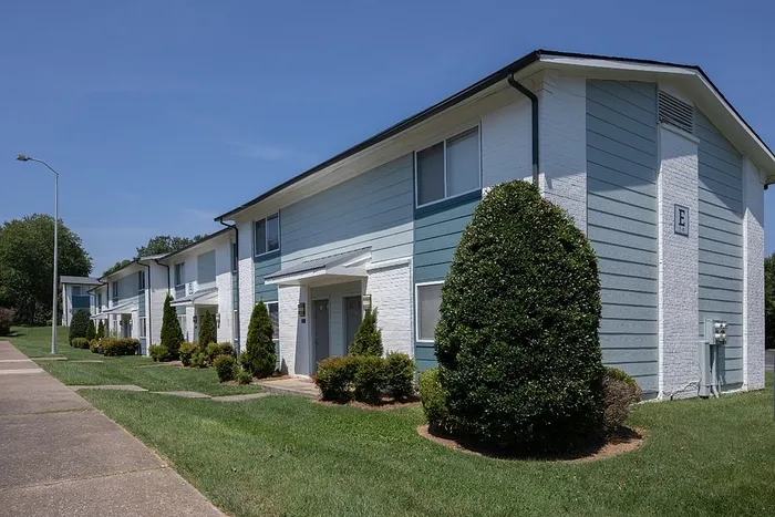 Charming apartment complex with inviting landscaping and modern two-story design, perfect for comfortable living.
