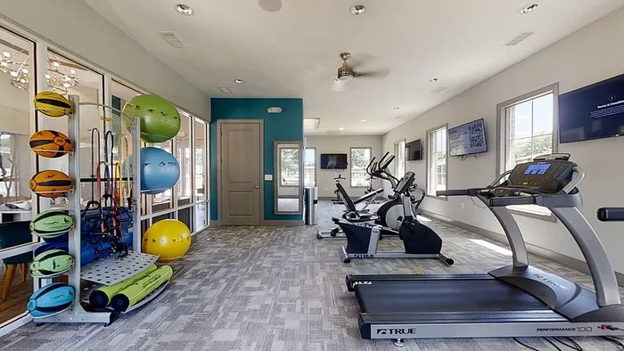 Bright and modern fitness center featuring high-end exercise equipment, scenic windows, and vibrant workout accessories.