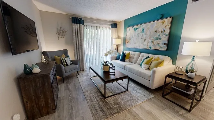 Bright and inviting living room with a cozy sofa, modern decor, and ample natural light from large windows.