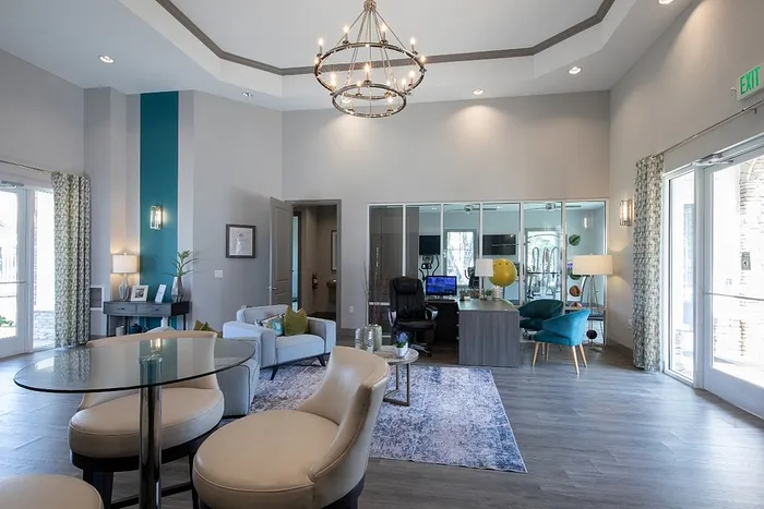 Inviting and spacious living area with modern decor, elegant lighting, and a glass-top table, perfect for relaxation and entertaining.