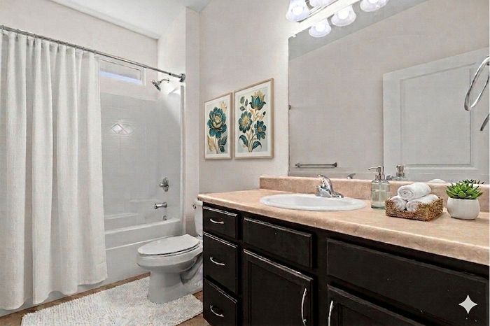 Charming bathroom with elegant dark wood vanity, modern lighting, and serene decor.