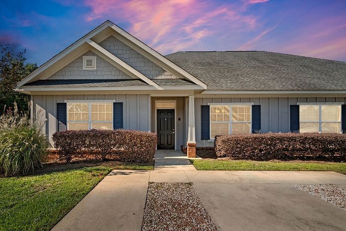 Charming single-story home with classic architecture, featuring a welcoming facade, well-manicured lawn, and beautiful evening sky backdrop.