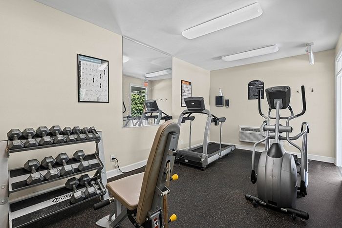 Inviting fitness room equipped with a variety of exercise machines and a set of free weights, ideal for your workout routine.