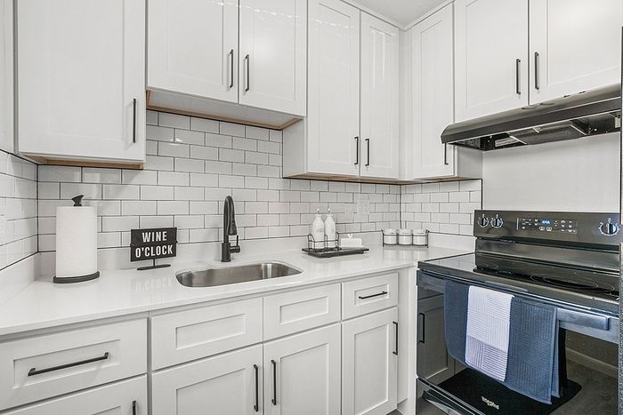 Modern kitchen with sleek white cabinets, subway tile backsplash, and stainless steel appliances providing a chic and functional cooking space.