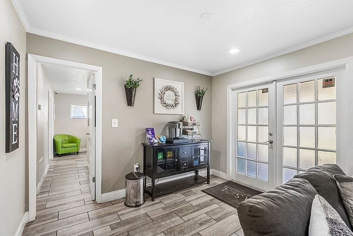 Welcoming entryway with elegant wood flooring, inviting natural light through French doors, and stylish modern decor.