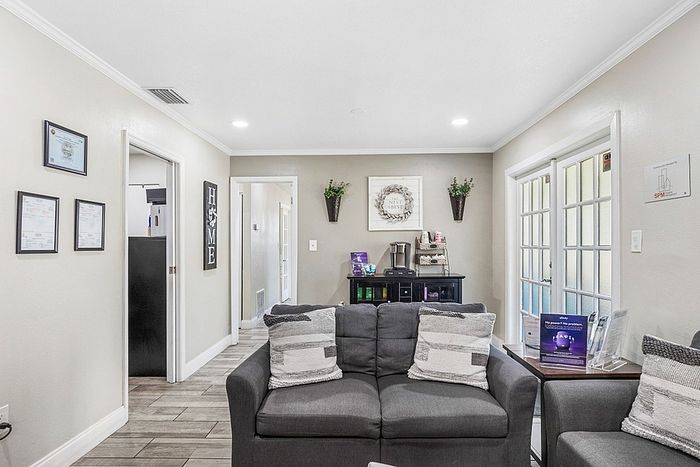 Charming living space with cozy seating, natural light through French doors, and tasteful decor creating a welcoming atmosphere.