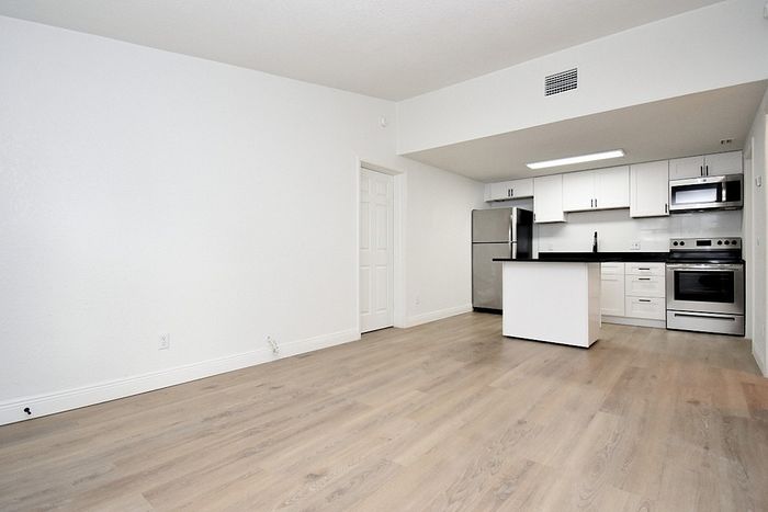 Sleek modern kitchen with stainless steel appliances, white cabinetry, and an inviting open floor plan, ideal for stylish living.