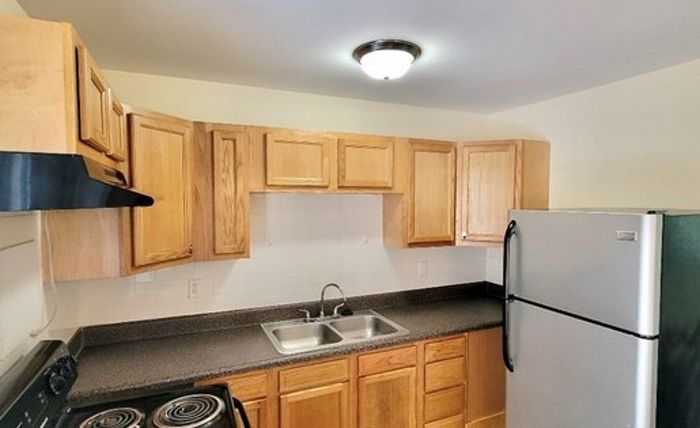 Cozy kitchen with sleek countertops, wooden cabinets, and modern appliances.