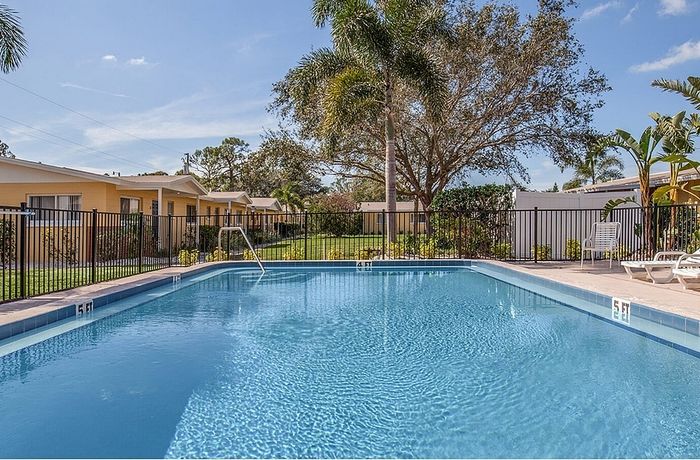Inviting outdoor pool area surrounded by lush greenery and vibrant tropical landscaping, offering a serene retreat.
