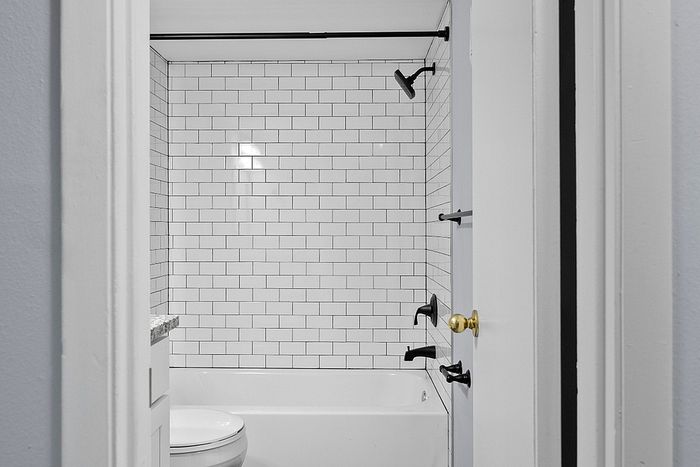 Chic bathroom featuring elegant subway tile design and modern black fixtures.