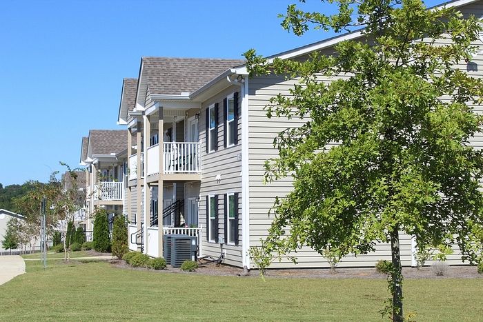 Charming apartment complex with inviting balconies and lush green surroundings.