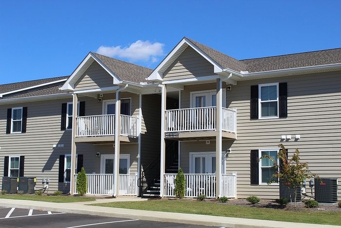 Charming modern apartment building with private balconies, offering spacious living in a peaceful neighborhood setting.