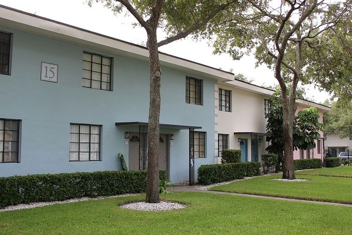 Charming apartment complex with colorful facades, well-maintained greenery, and inviting pathways.