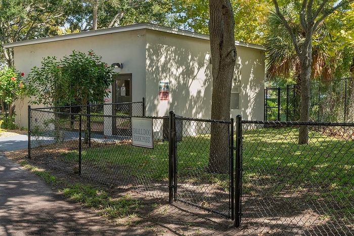 Charming small dog park with a fenced area and lush greenery, perfect for pet-friendly community living.