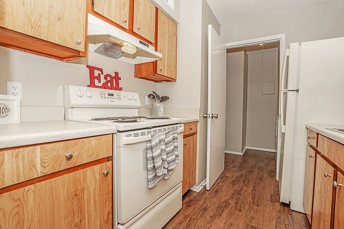 Cozy kitchen with stylish wooden cabinets, modern appliances, and charming decor, perfect for cooking enthusiasts.
