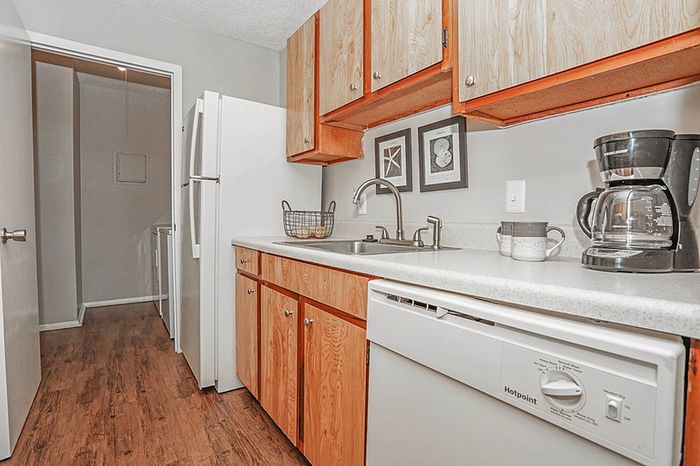 Inviting kitchen with warm wooden cabinets, modern appliances, and elegant countertops, perfect for culinary adventures.