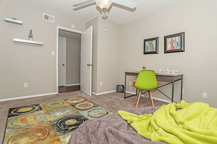 Bright and cozy bedroom with modern decor, stylish rug, and chic desk, ideal for relaxation and work.